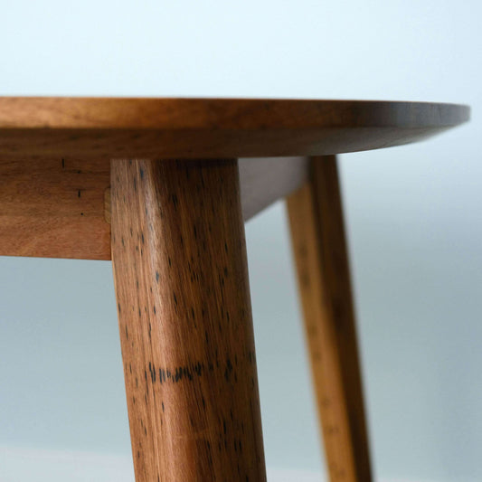 Close-up of a recycled timber dining table with a blurred background
