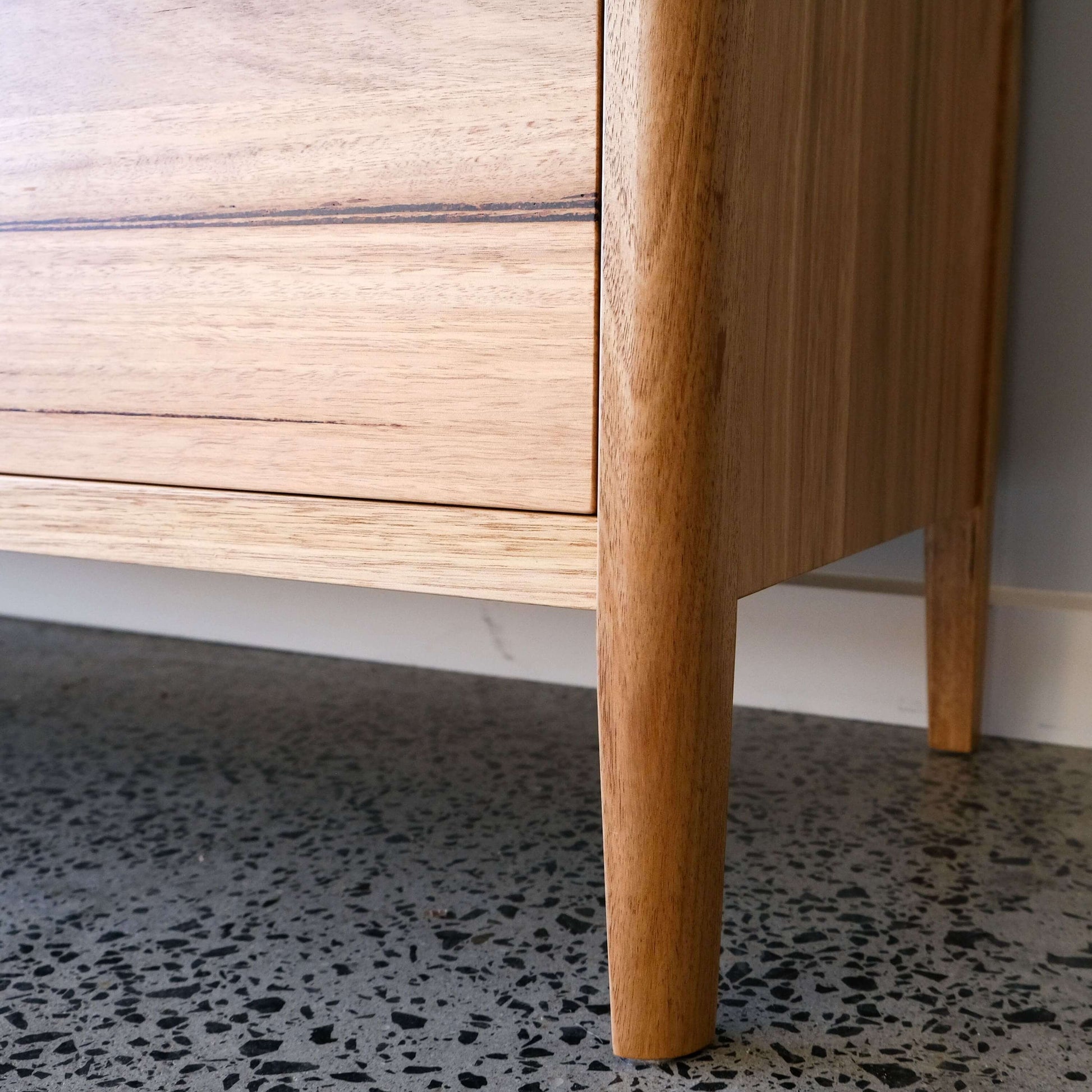 Close-up of Mayfield sideboard in Wormy Chestnut, showcasing tapered legs and timber texture.
