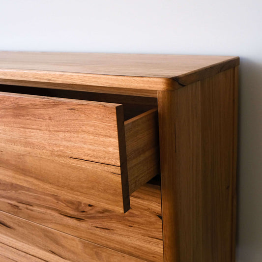 Close-up of the Mayfield sideboard in Wormy Chestnut with a drawer partially open, showcasing its timber design.