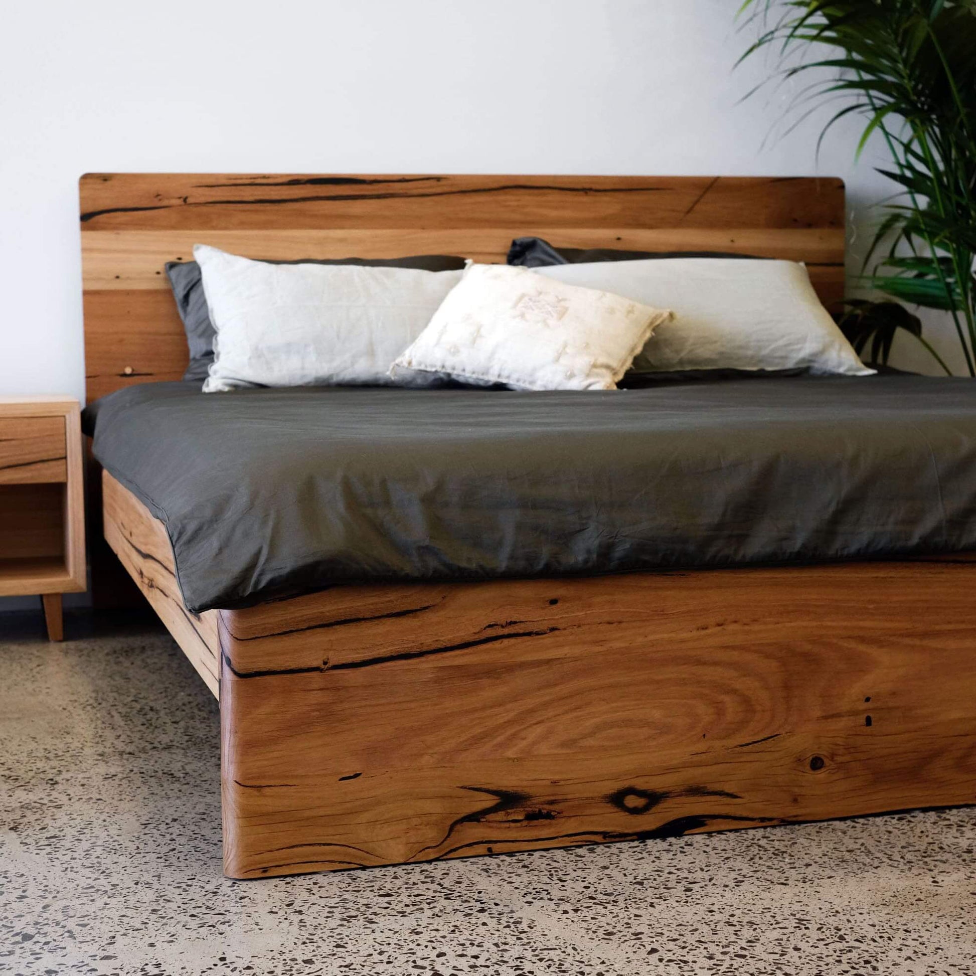 Sleek Plymouth Panel Timber Bed made of recycled timber with curved edges and soft bedding.
